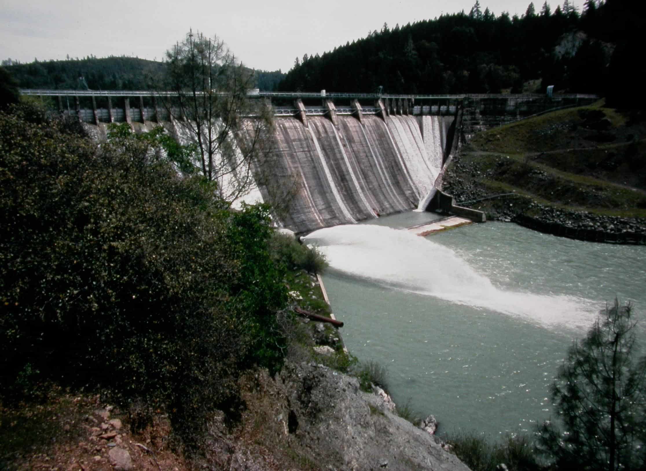 Water spouts out of Scott Dam on a grey day.