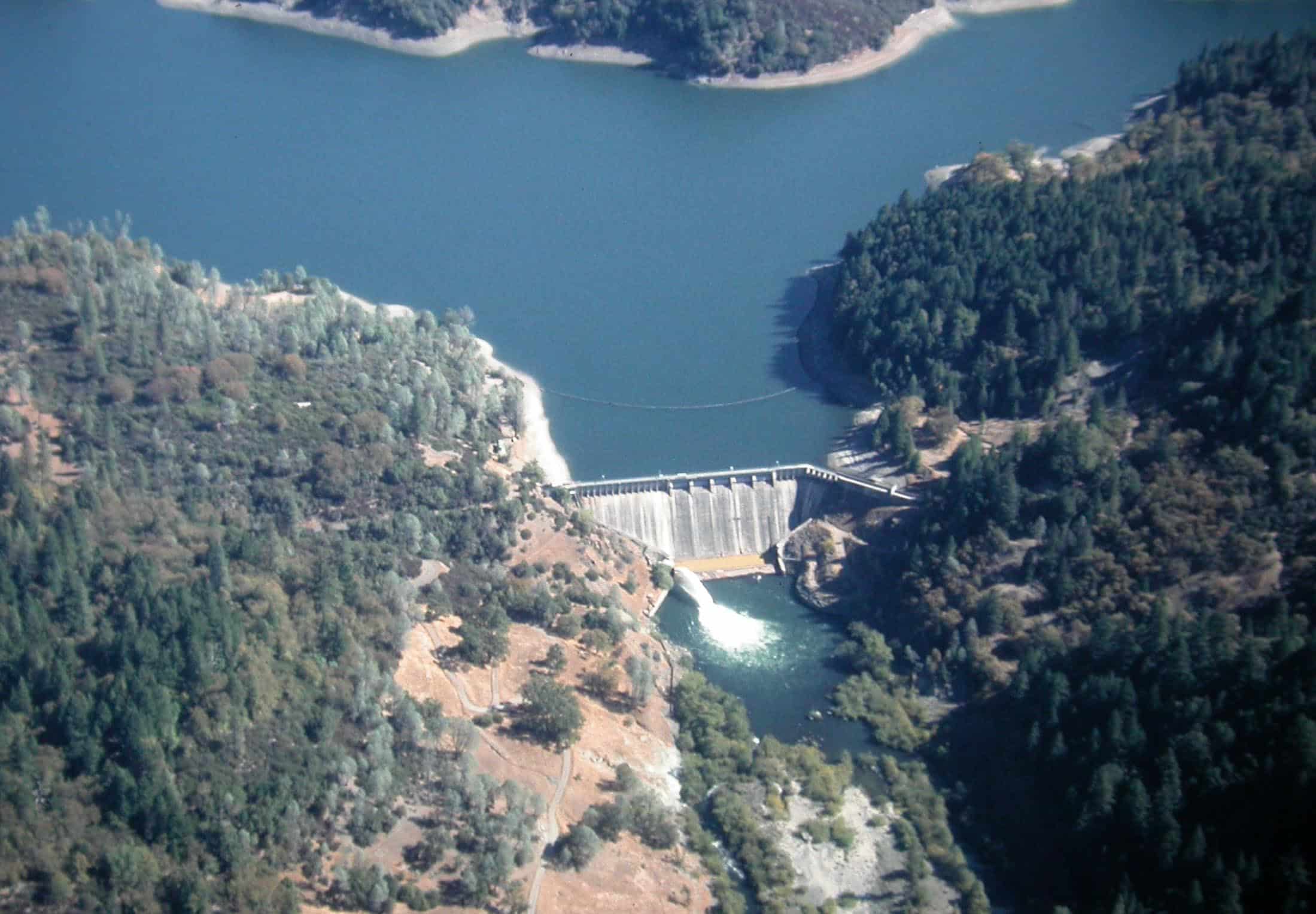 Scott Dam impounds Lake Pillsbury, with water flowing into a dry-looking Eel River below the dam.